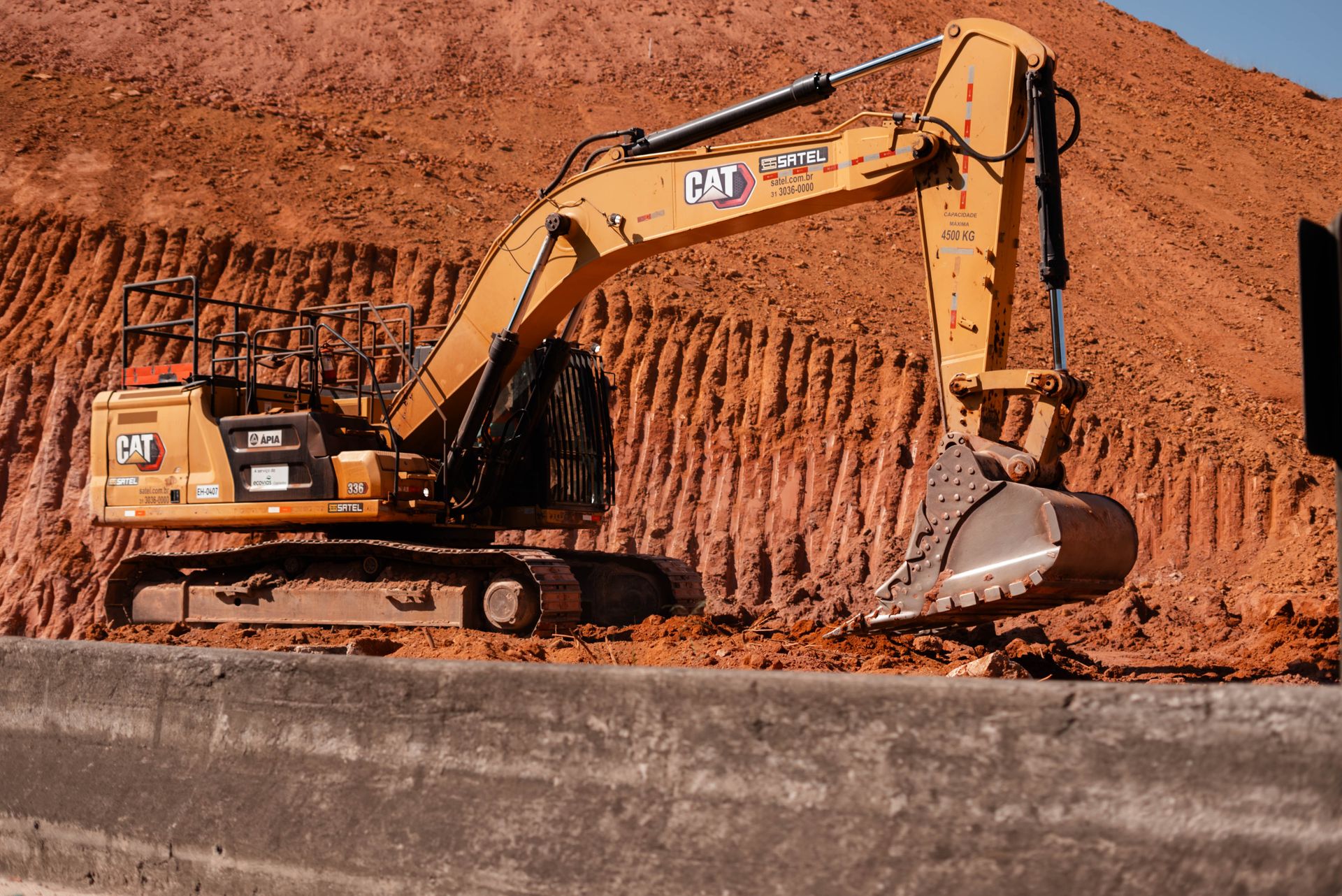 Excavator working red earth on a haul road